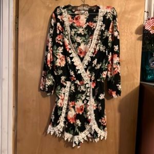 Floral black romper with sleeves and white lace trim & plunging neckline size L